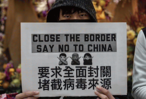 A picture of a member of Hong Kong's pro-U.S. fascist movement. Their sign is a response to Covid-19. A picture of a member of Hong Kong's pro-U.S. fascist movement. Their sign is a response to Covid-19.