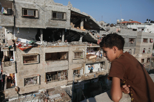 A young Palestinian boy surveys the homes in Gaza destroyed by Israeli bombings., From Uploaded