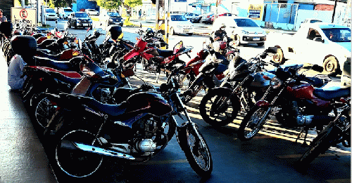 Motor bikes and small engine motorcycles parked at a supermarket., From Uploaded