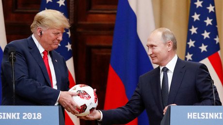 Donald Trump receives a football from Russian President Vladimir Putin in Helsinki, Finland July 16, 2018